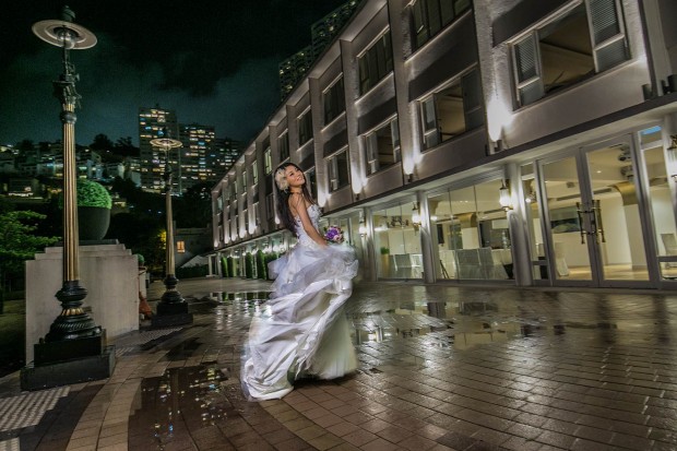 Bride in wedding gown dancing in the rain